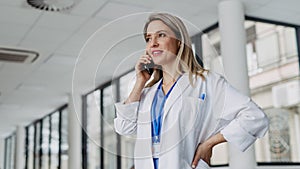 Portrait of doctor in hospital phone calling. Remote consultations with patient, telemedicine.