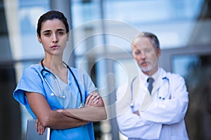 Portrait of doctor and nurse standing with arms crossed