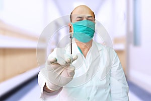 Portrait of Doctor wearing mask holding syringe Covid-19 or coronavirus vaccine at a hospital, Pfizer, COVISHIELD & COVAXIN Dose photo