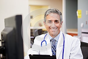 Portrait Of Doctor Working At Nurses Station