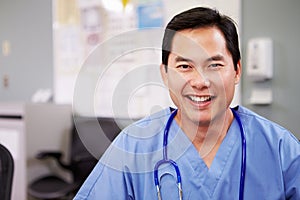 Portrait Of Doctor Working At Nurses Station