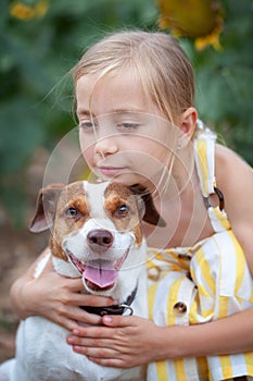 Portrait of a dog hugged by a little girl in nature. The special bond between a child and a dog