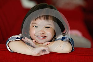 Portrait of a down syndrome baby girl smiling with happiness and play with camera