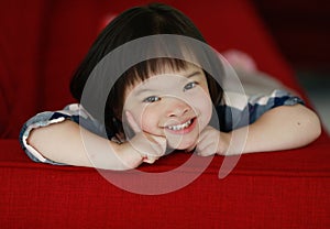 Portrait of a down syndrome baby girl smiling with happiness and play with camera