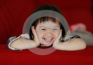 Portrait of a down syndrome baby girl smiling with happiness and play with camera