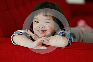 Portrait of a down syndrome baby girl smiling with happiness and play with camera