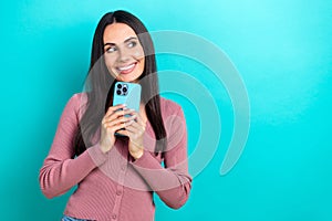 Portrait of dreamy lovely young girl wear pink shirt hold new smartphone look empty space want itunes subscription