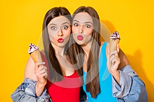 Portrait of dreamy sisters youngsters have fun on summer time weekend hold tasty icecream scoops send air kiss wear