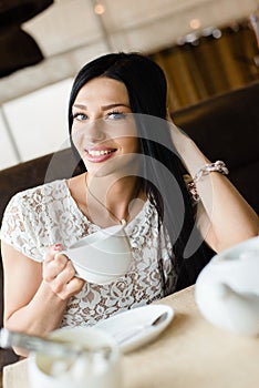Portrait of drinking coffee or tea beautiful brunette girl young woman having fun gently smiling and looking at camera
