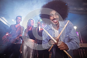 Portrait of drummer holding drum sticks at nightclub