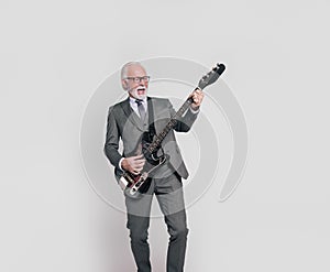 Portrait of ecstatic senior male professional playing electric guitar on isolated white background