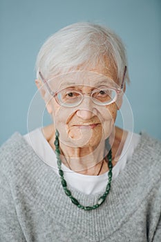 Portrait of elderely grey haired woman in a comfortable sweater at home