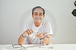 Portrait of elderly asian man taking medicine every day