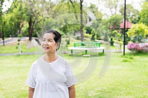 Portrait of a elderly asian woman standing and looking something at park,Happy and smiling