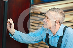 Portrait of an elderly carpenter at work in a carpentry shop