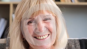 Portrait of an elderly Caucasian woman laughing while looking at the camera. Happy pensioner