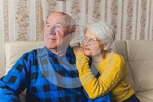 Portrait of an elderly couple - caring husband standing behind his happy loving wife and hugging her and a woman herself