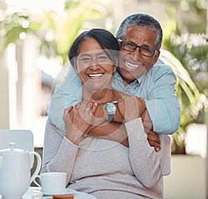 Portrait of elderly couple hug and bonding, happy and enjoying tea break at home together. Retirement, love and smiling