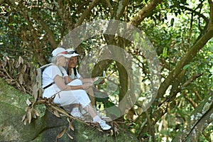 Portrait of elderly couple resting in tropical garden outdoors