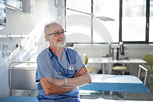 Portrait of elderly doctor at hospital room.