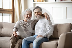 Portrait of elderly father hugging with adult son