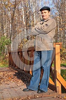 Portrait of elderly man in black hat in wood