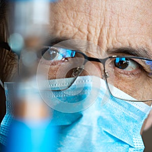 Portrait of an elderly man in glasses and a medical mask