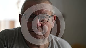 Portrait of an elderly man with glasses. The old man looks at the camera. The look of a tired man, old age and