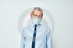 Portrait elderly man medical mask protection light background