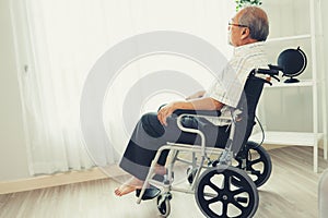 Portrait of an elderly man in a wheelchair contented and alone at home.