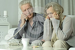 Portrait of elderly man and woman with telephone.