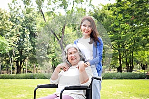 Portrait of an elderly mother in a wheelchair with her daughter or caregiver.