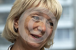 Portrait of an elderly smiling woman on a neutral background, close-up. Perhaps she is an elderly music teacher, a retired grandmo