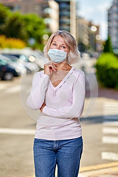 Portrait elderly woman with a dog outdoors an antivirus mask