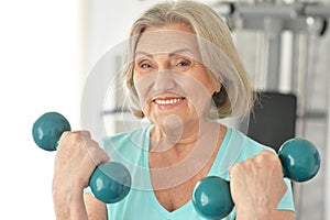 Elderly woman exercising in gym