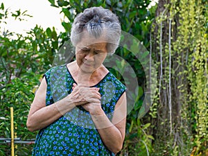 Portrait of elderly woman having heart attack