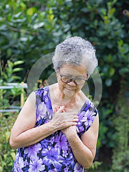 Portrait of an elderly woman having a heart attack. A senior woman clutching her chest in pain at the first signs of angina