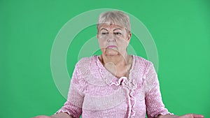 Portrait elderly woman looking at the camera and making a dont know gesture and shrugs. Gray haired grandmother with