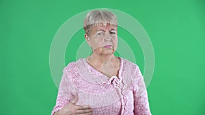 Portrait elderly woman looking at the camera scolding someone and threatening shaking her index finger. Gray haired