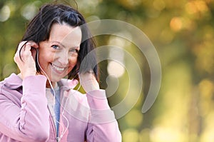 Portrait of elderly woman prepare to jog with headphones in the park