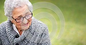 Portrait elderly woman sitting on bench in park smiling looking thoughtful enjoying retirement contemplating life