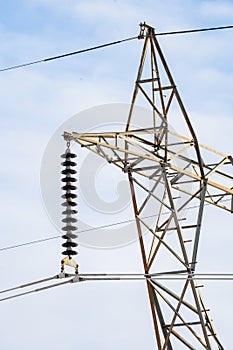 Portrait electrical pylon view with power lines hanging from steel lattice and hardware in North America