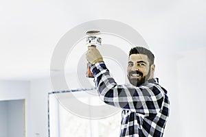 Portrait of an electrician happy worker at work install light