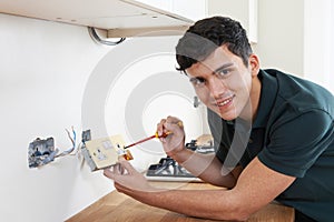 Portrait Of Electrician Installing Socket In New House