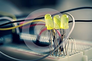 A portrait of an electronic circuit of LEDS on a breadboard with wires all around them