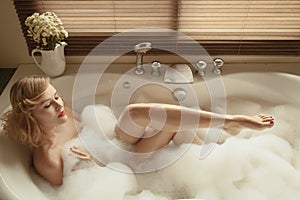 Elegant beautiful woman relaxing in a spa bath photo