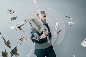 Portrait of elegant businessman with falling dollar banknotes