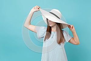 Portrait of elegant fashion beautiful young woman in white summer large wide brim sun hat, dress put hands on head