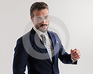 portrait of elegant fashion man with glasses looking forward and posing