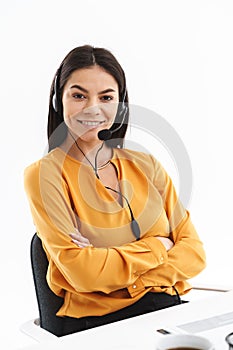 Portrait of elegant hotline assistant woman wearing microphone headset speaking with customer by phone in office